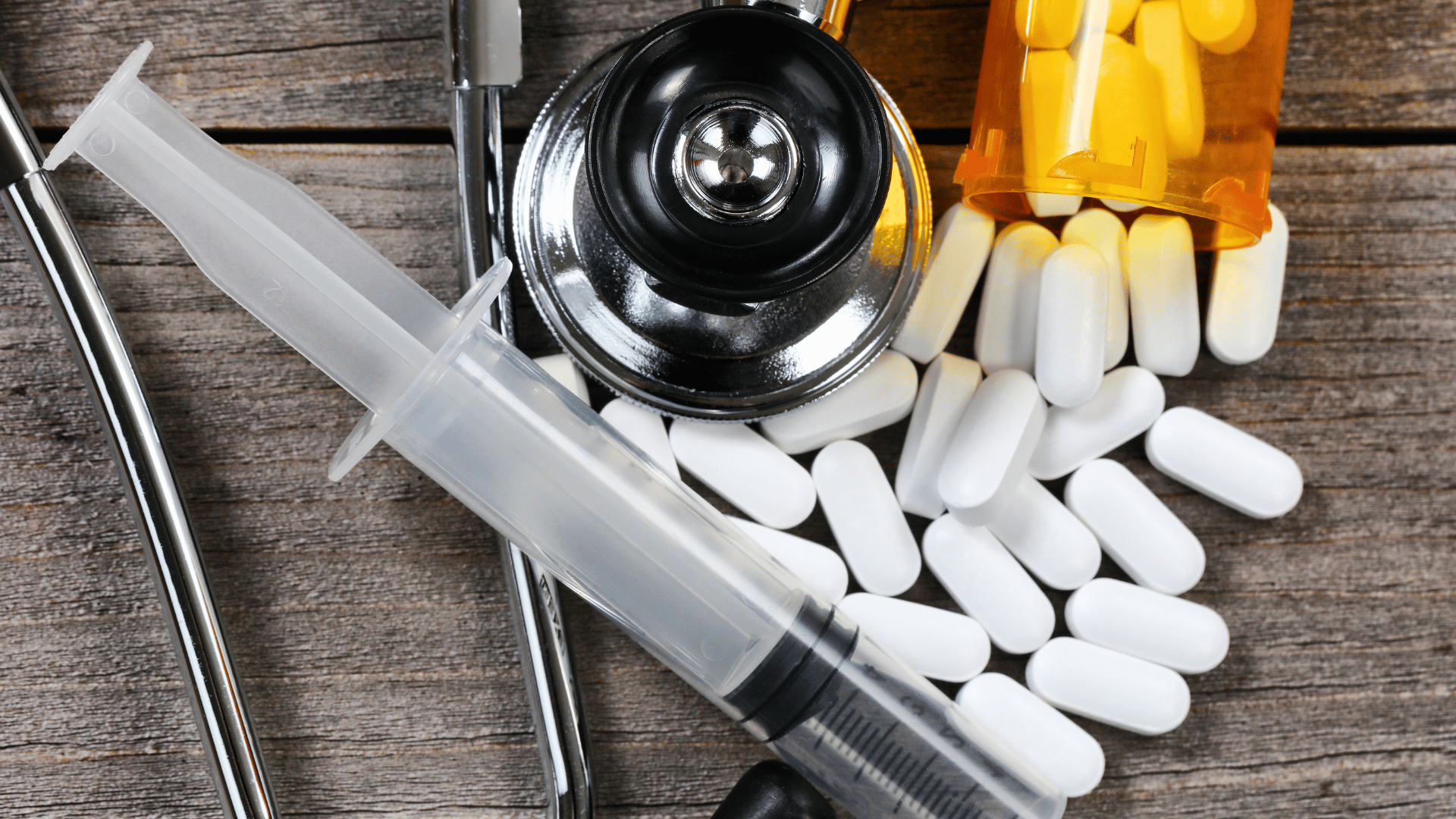 opioids, syringe and stethoscope on a table