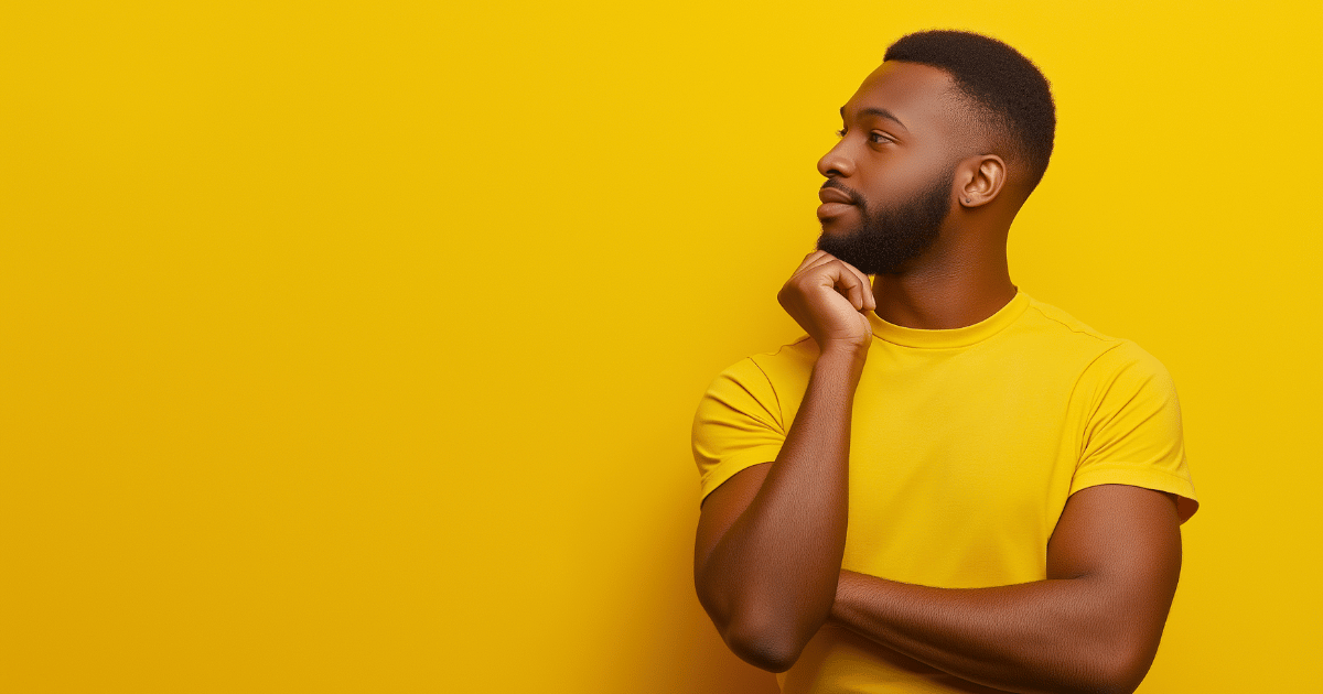 Man pondering, looking off to the left in front of a bright yellow background